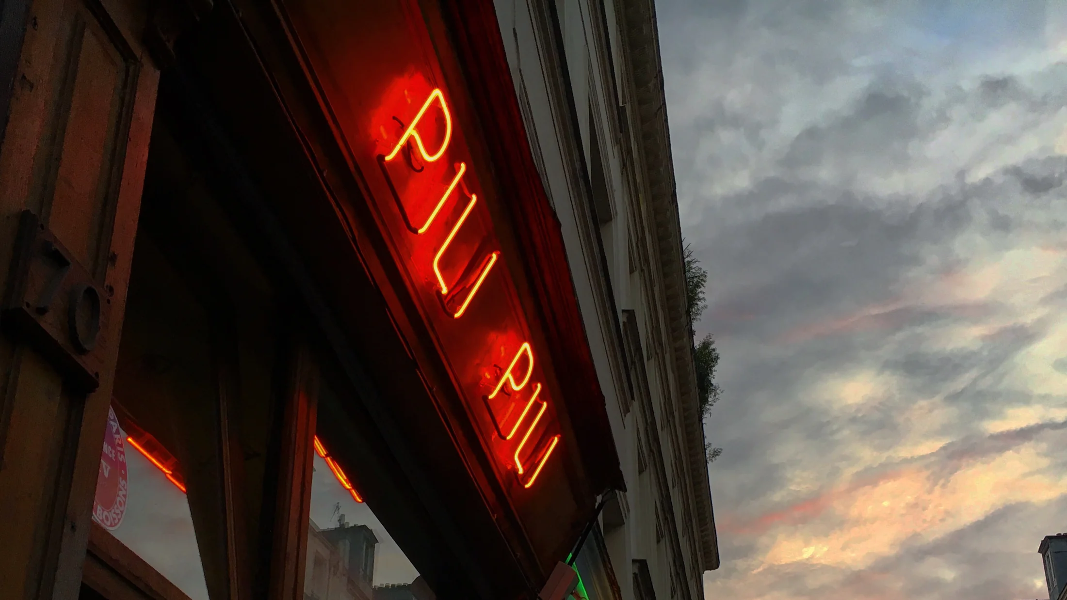 Enseigne néon PILI PILI au crépuscule